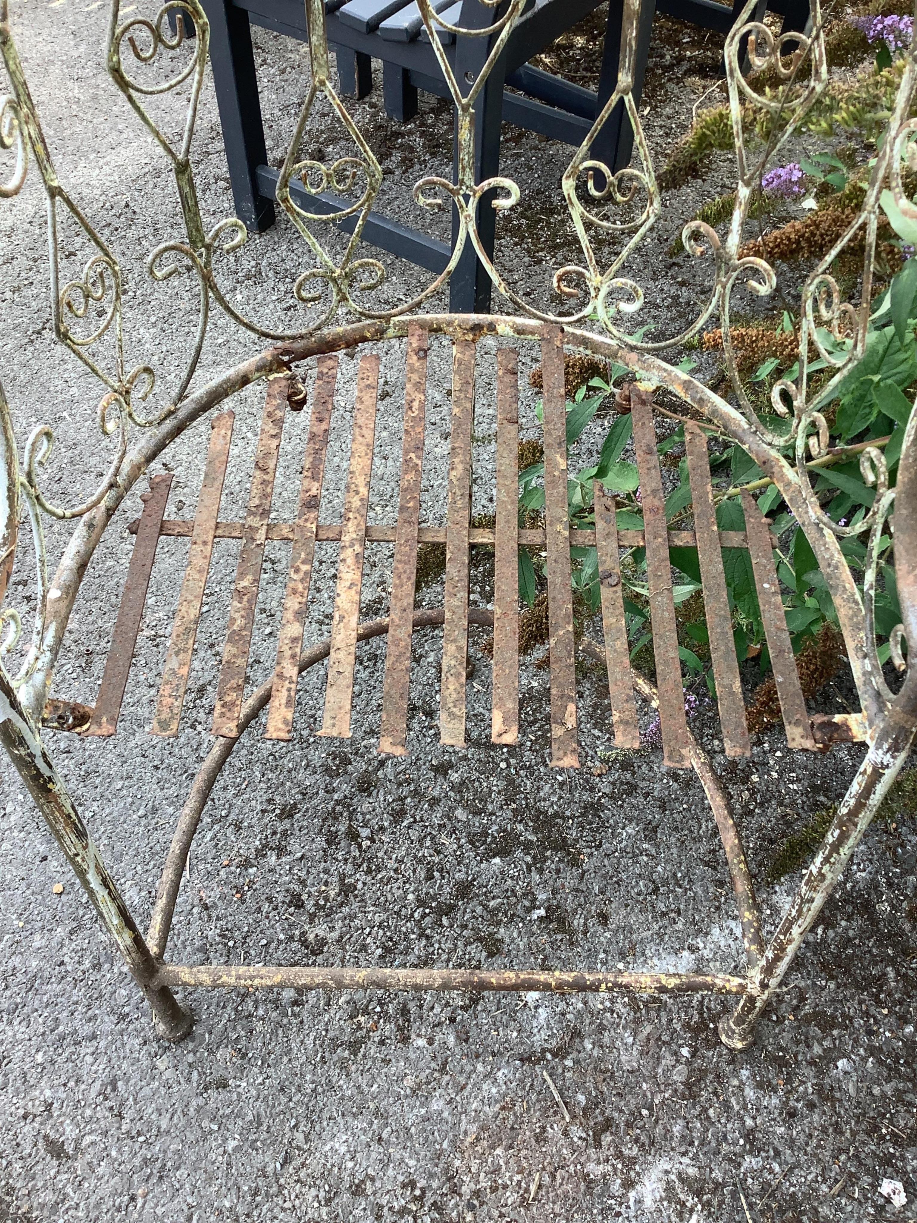 A painted wrought iron garden arbour seat, width 203cm, depth 55cm, height 250cm. Condition - poor